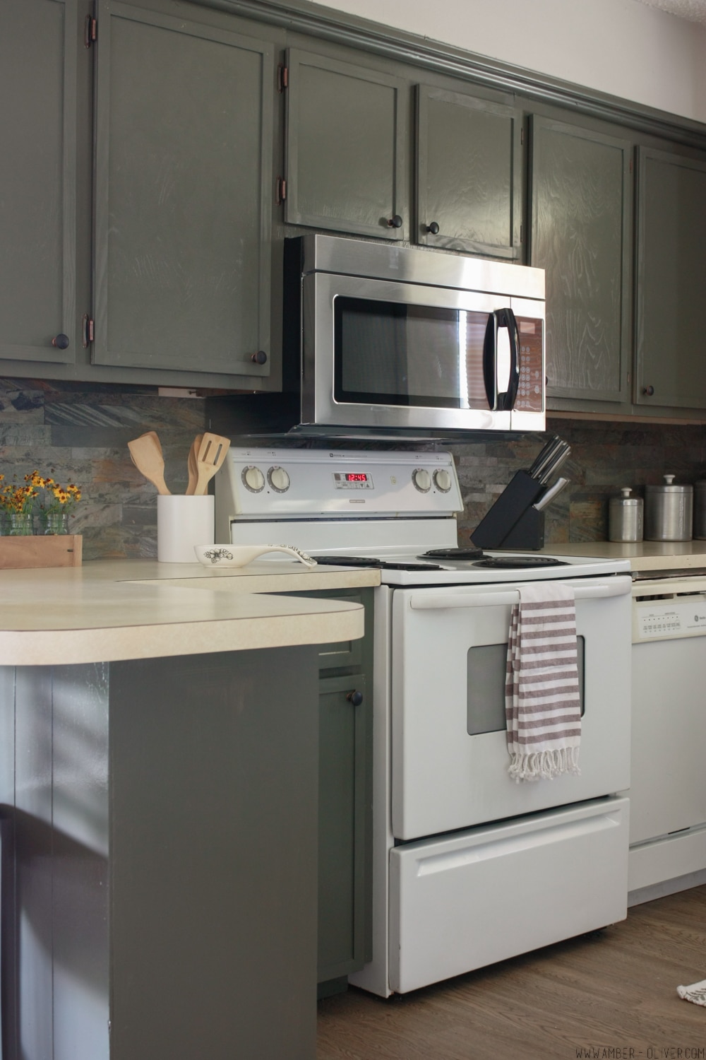 Kitchen remodel on a budget! Dark painted cabinets, peel and stick backsplash, and updated old cabinet doors!