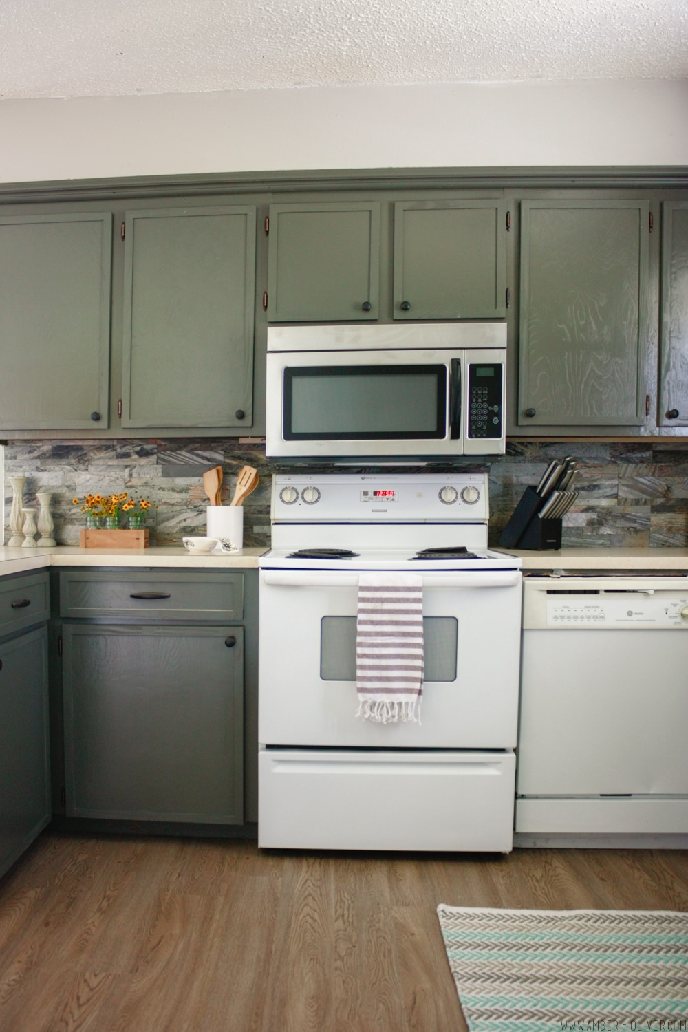 Kitchen remodel on a budget! Dark painted cabinets, peel and stick backsplash, and updated old cabinet doors!