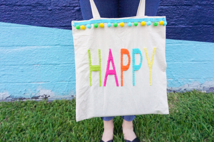happy tote bag holding on grass