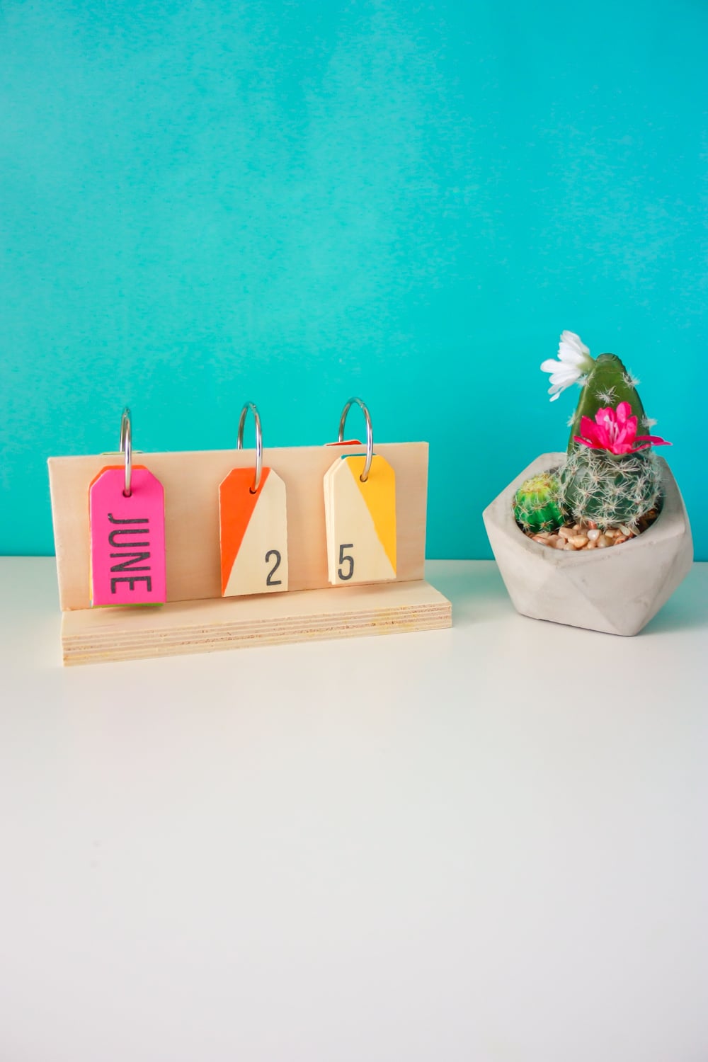 How to make a perpetual calendar for a colorful way to display the date! You'll need wood pieces, wooden tags, glue, metal rings, paint, and a drill.