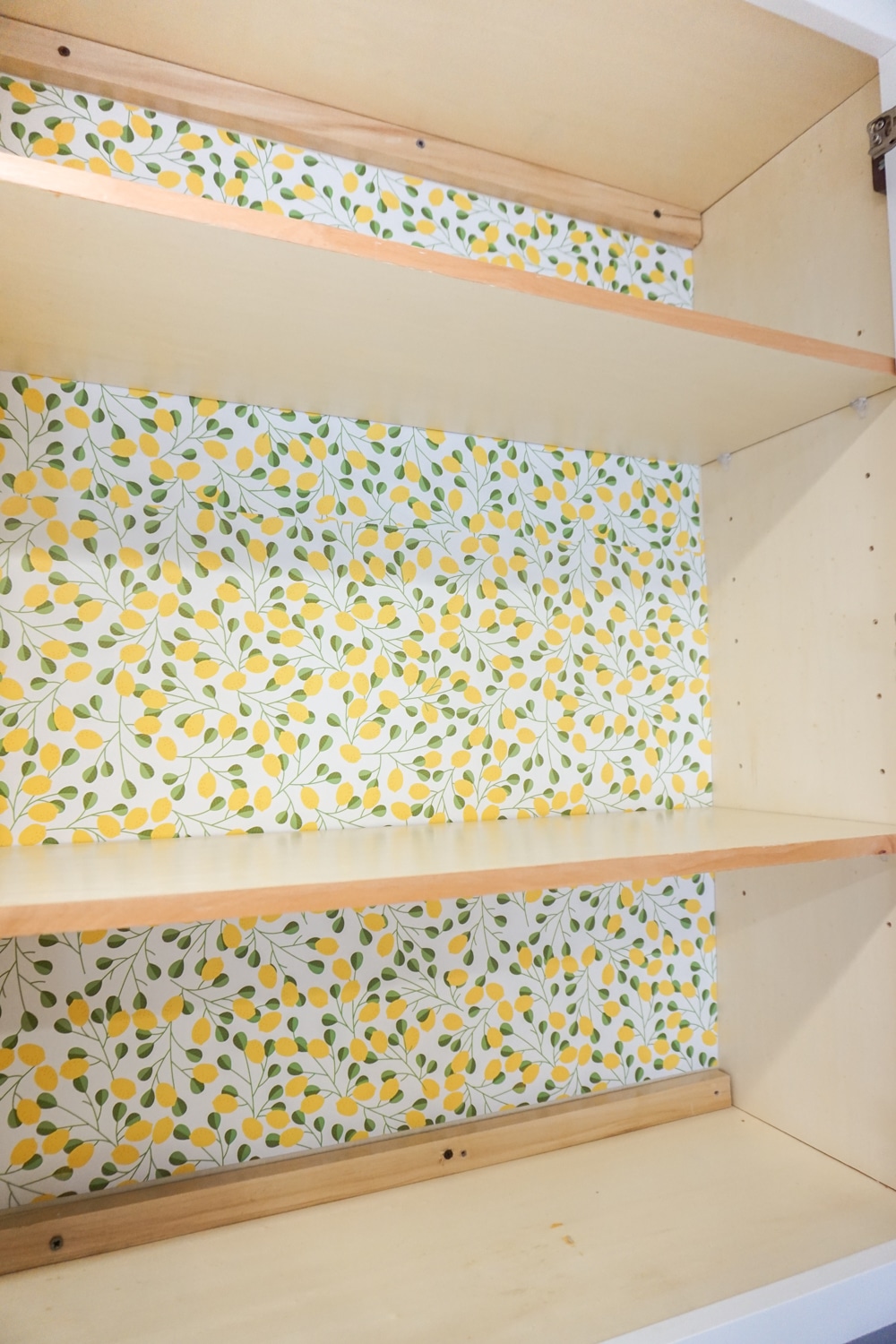 Organizing baking supplies is easy with cork tiles, command hooks, vinyl labels, and a beautiful craft paper to line the cabinet.