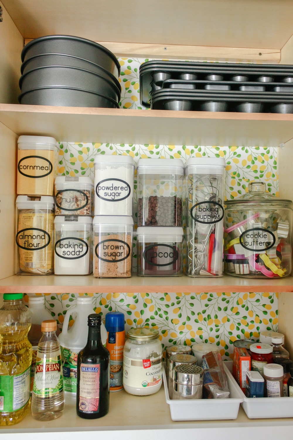 Organizing baking supplies is easy with cork tiles, command hooks, vinyl labels, and a beautiful craft paper to line the cabinet.