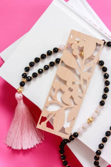 Beautiful wooden bookmark laying on a stack of books