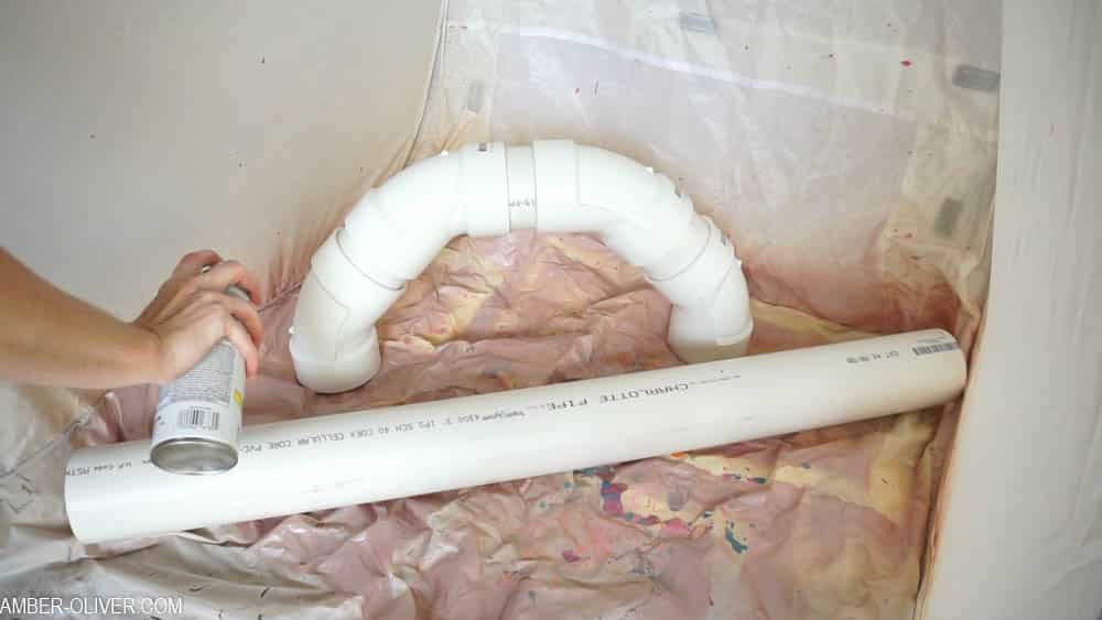 How to Make DIY Lighted PVC Candy Canes: spray painting with white paint