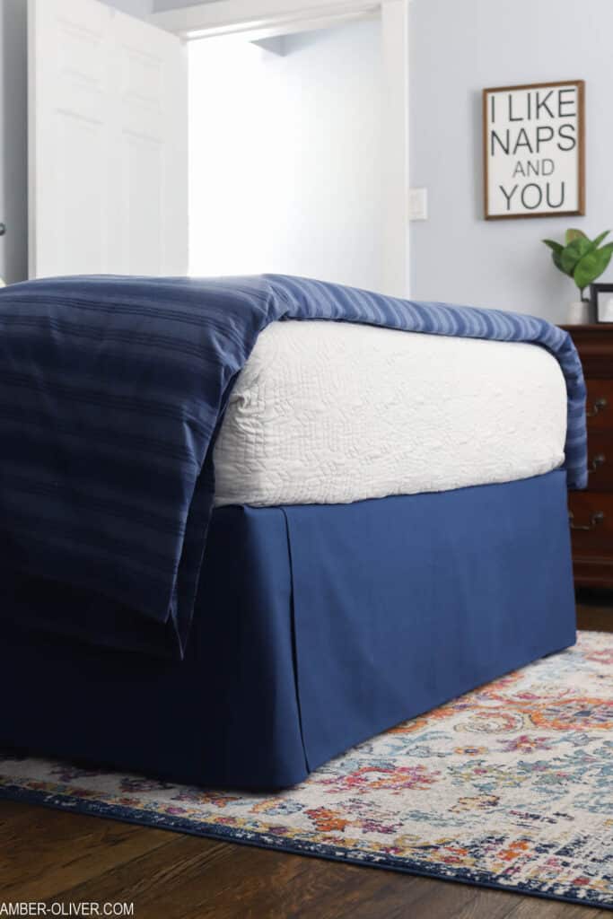 room with navy diy bedskirt and colorful rug