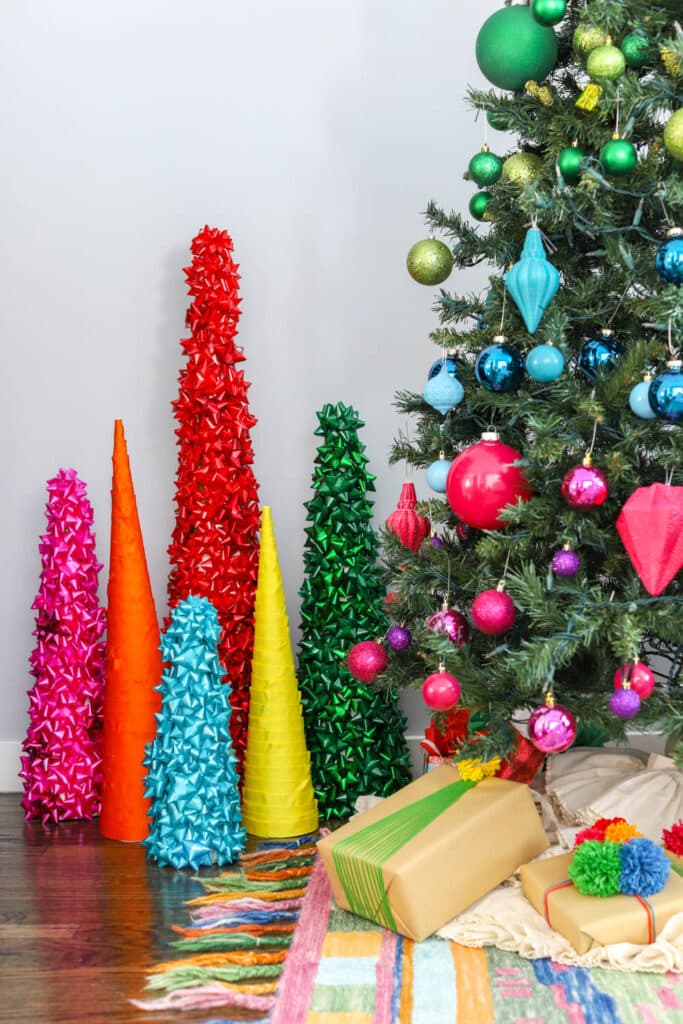 rainbow cone christmas trees in front on large tree