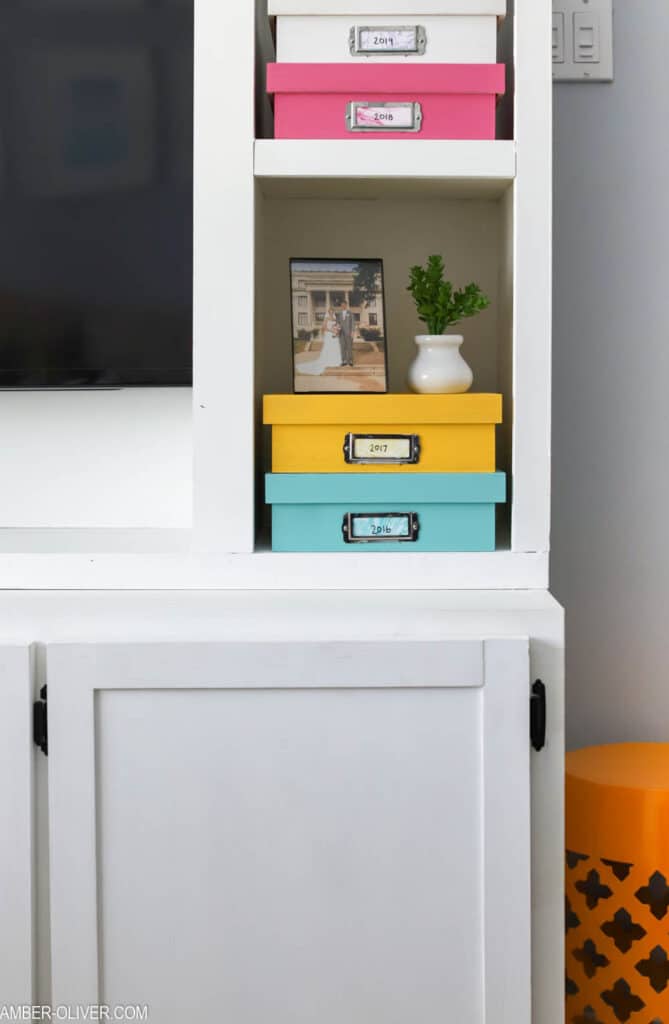 white diy entertainment center with memory boxes on the shelves