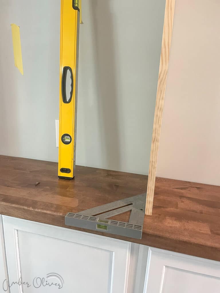 make sure vertical boards are level for diy bookshelf wall