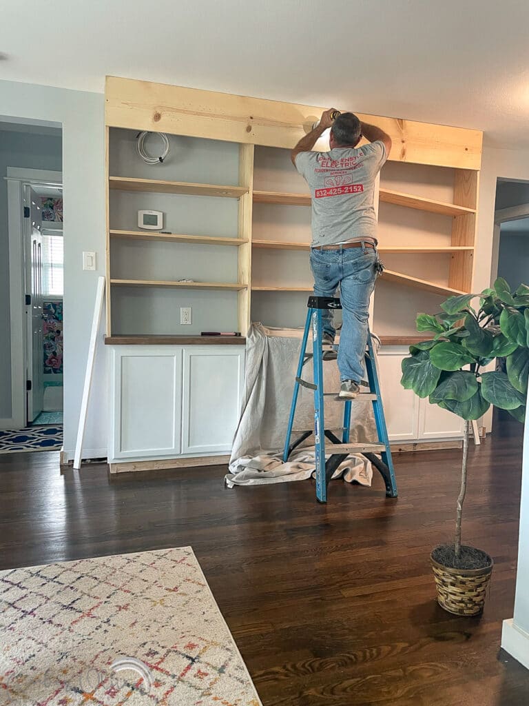 electrician installing lights on diy bookcase