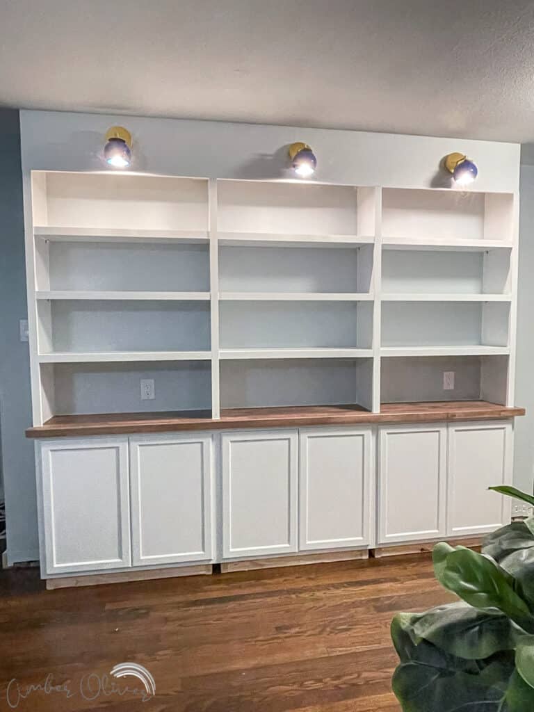 painted diy bookcase with lighted sconces