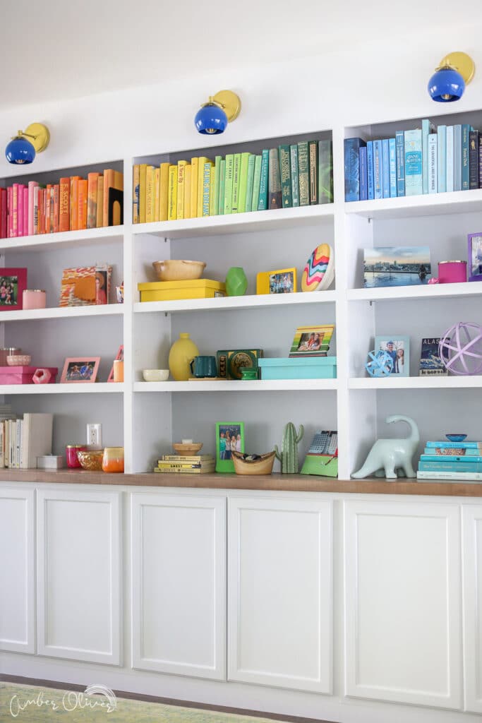 vertical view of the rainbow DIY bookshelf with the built in cabinets