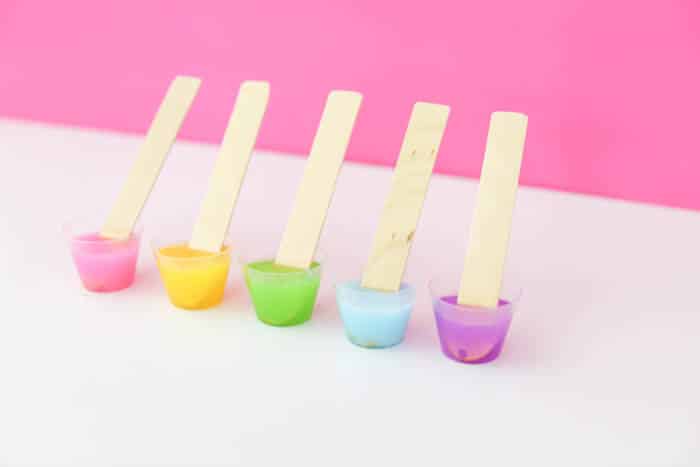 colorful resin in tiny cups with stir sticks