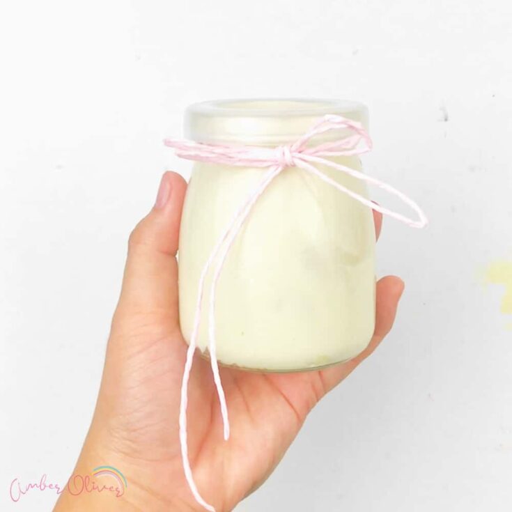 holding diy whipped lotion in a jar with ribbon